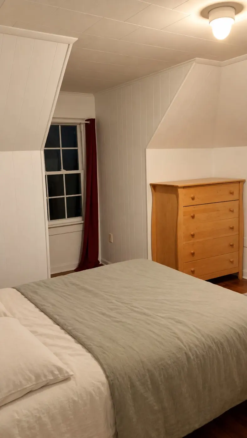 Temporary staged bedroom with sloped ceiling and green bedding