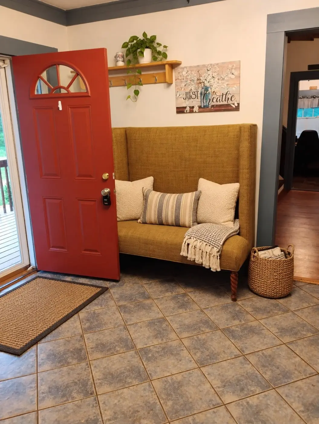 Temporary staged foyer view with red entry door and bench seating